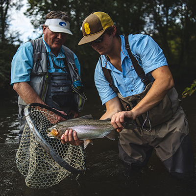 two men putting a fish into a fishing net